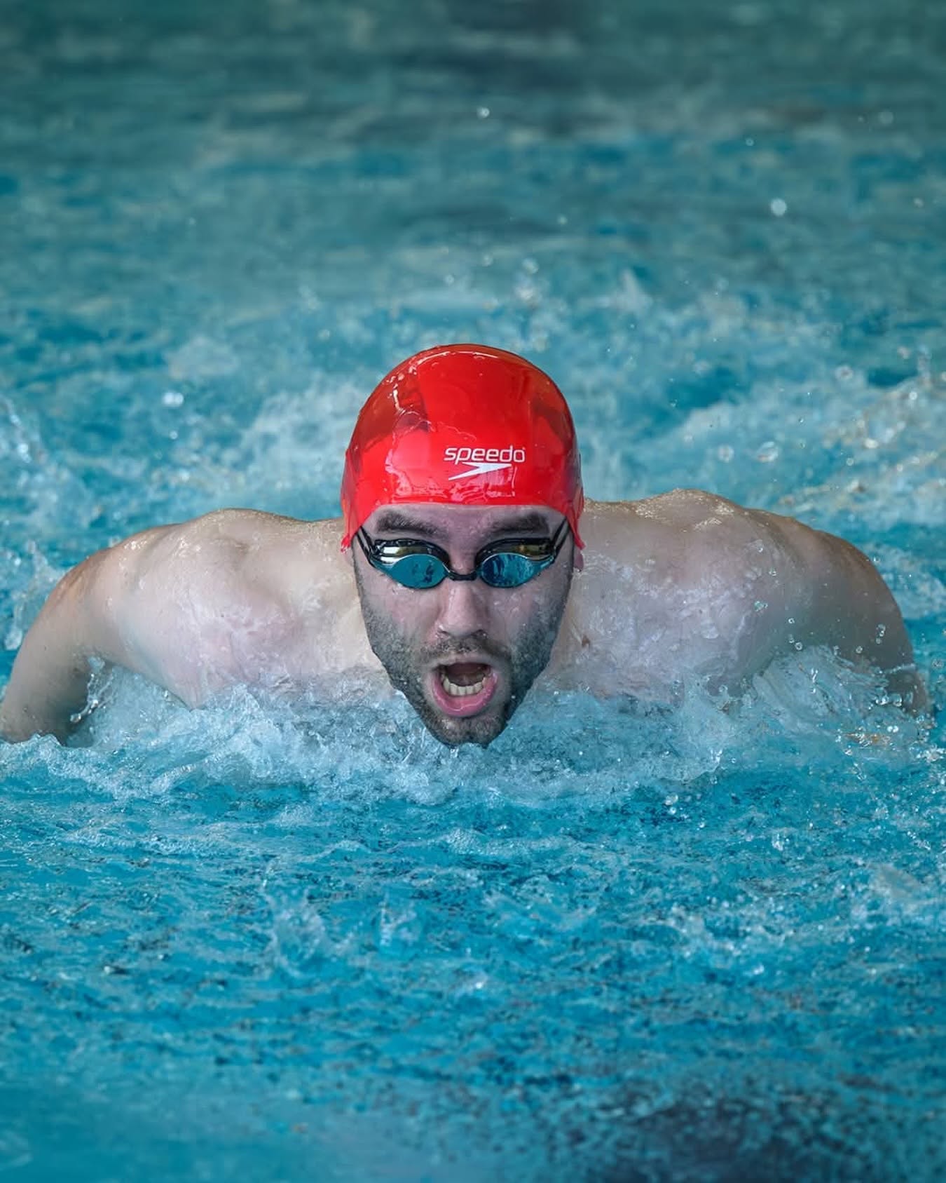 A swimmer training butterfly in the pool